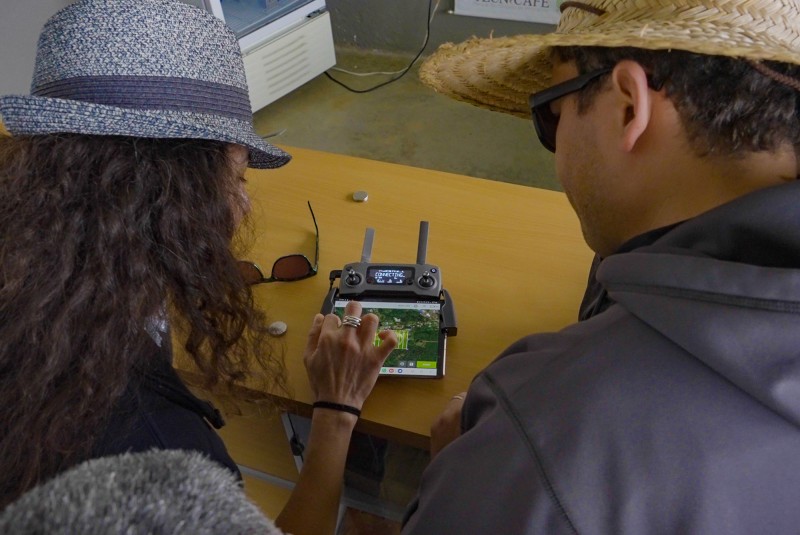 Over shoulder view of two researchers leaning together over a drone control console